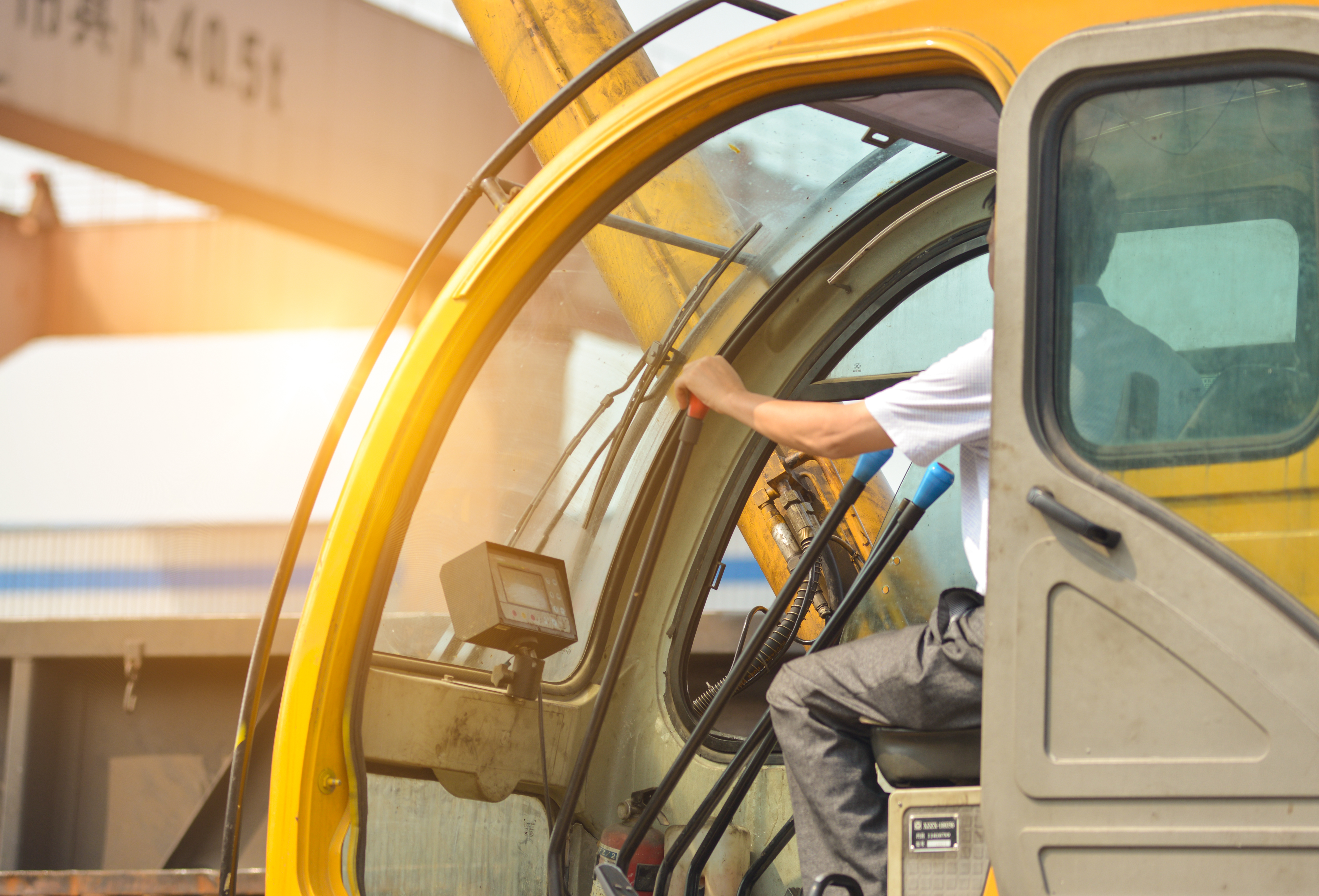 Man driving a crane to lift-up some equipment photo leading to Workers Comp page